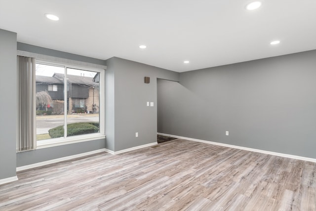 unfurnished room with light wood-style floors, baseboards, and recessed lighting