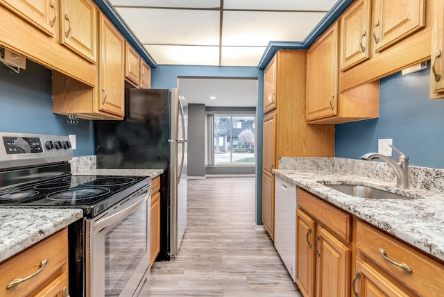 kitchen with light stone counters, white dishwasher, a sink, light wood-type flooring, and stainless steel range with electric stovetop