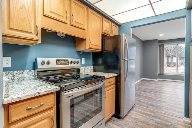kitchen featuring light wood-style floors, stainless steel electric range oven, baseboards, and light stone counters