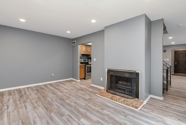 unfurnished living room featuring light wood finished floors, baseboards, and recessed lighting
