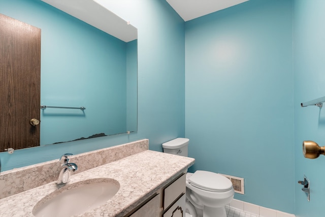 half bathroom featuring visible vents, vanity, and toilet