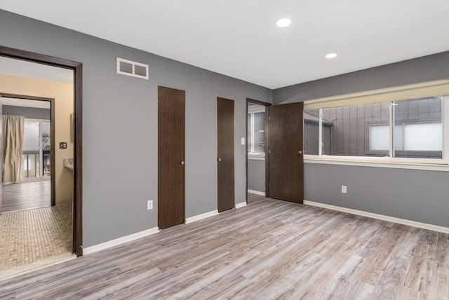 unfurnished bedroom featuring recessed lighting, visible vents, baseboards, and wood finished floors