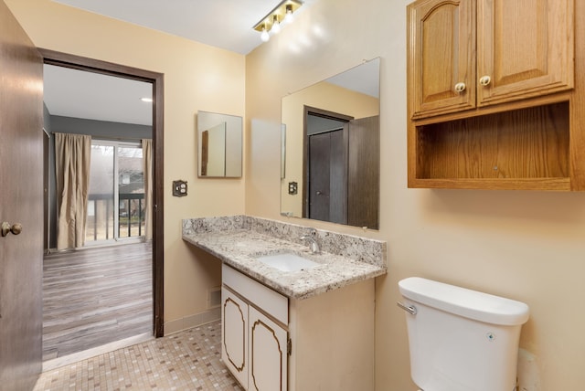 bathroom with toilet, tile patterned flooring, baseboards, and vanity