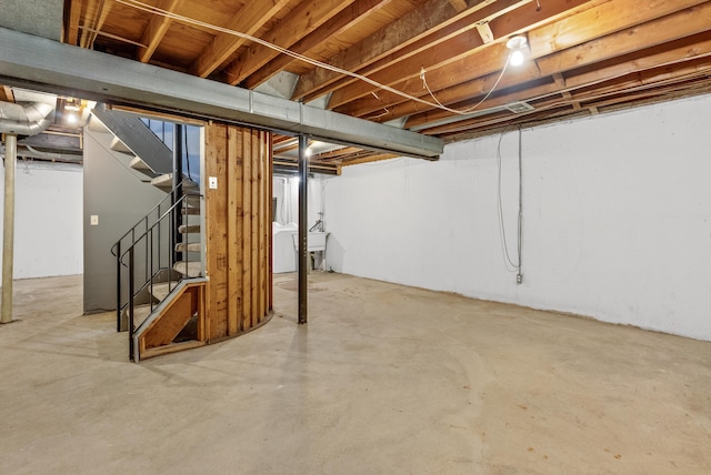 unfinished basement with stairway and washer / clothes dryer