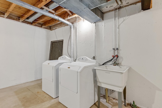washroom with laundry area, a sink, and independent washer and dryer