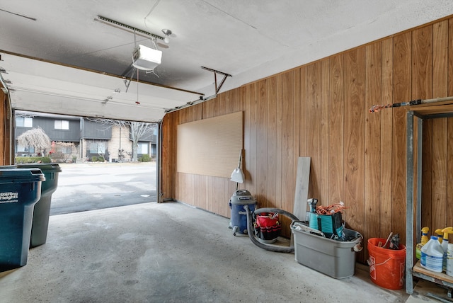 garage featuring a garage door opener and wood walls