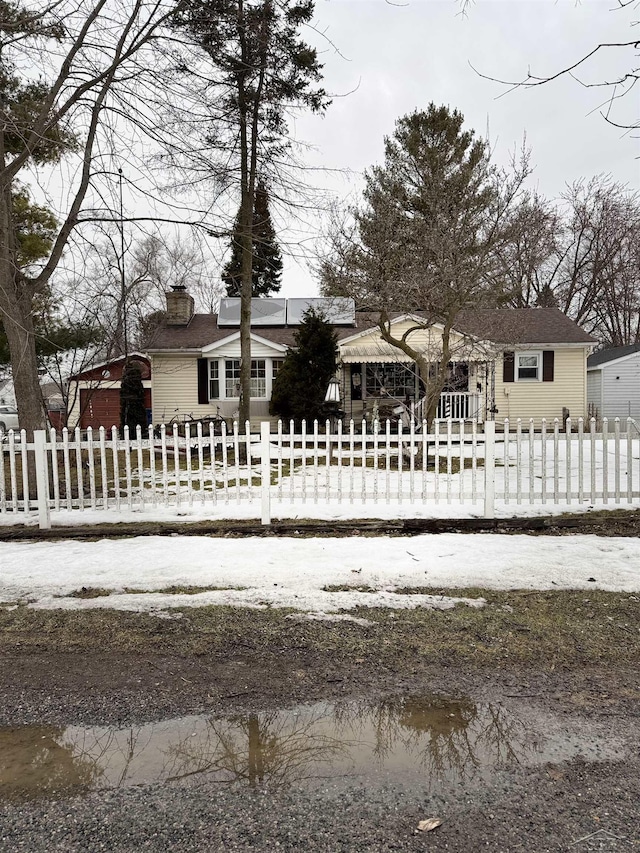 view of front facade with a fenced front yard and a chimney