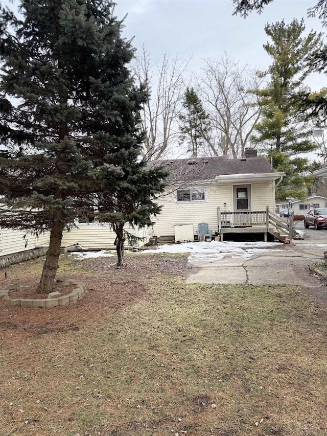 back of house featuring a chimney and a deck