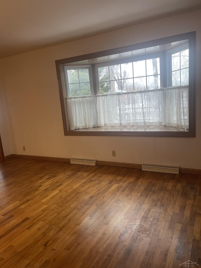 spare room with visible vents, baseboards, and wood finished floors