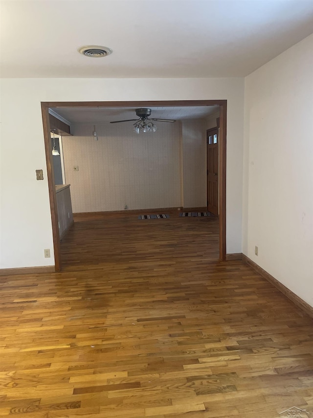 unfurnished room featuring visible vents, ceiling fan, baseboards, and wood finished floors