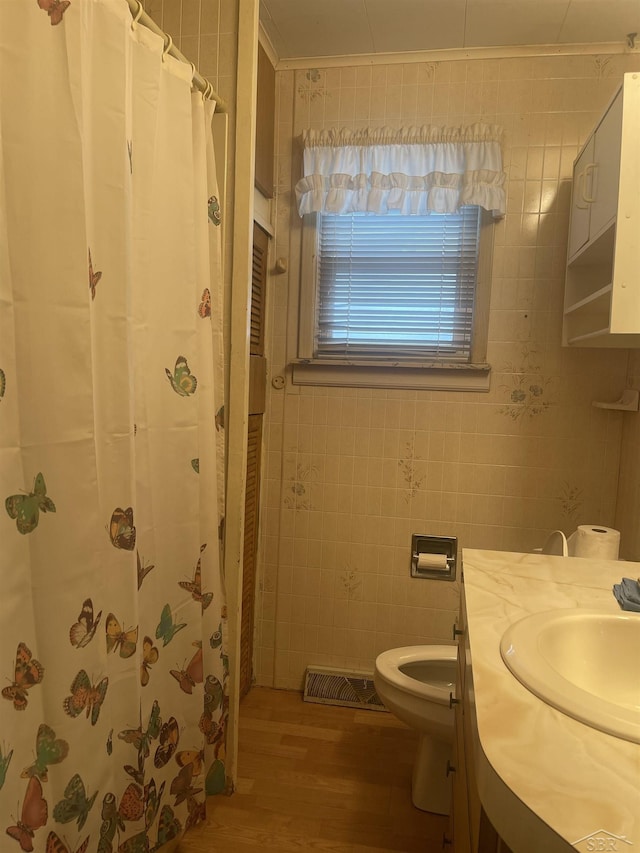 bathroom featuring tile walls, visible vents, toilet, ornamental molding, and wood finished floors