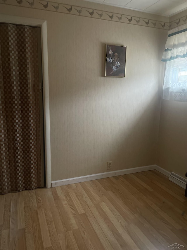 empty room with light wood-style floors and baseboards