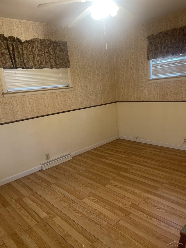 unfurnished room featuring baseboards, visible vents, light wood finished floors, and wallpapered walls