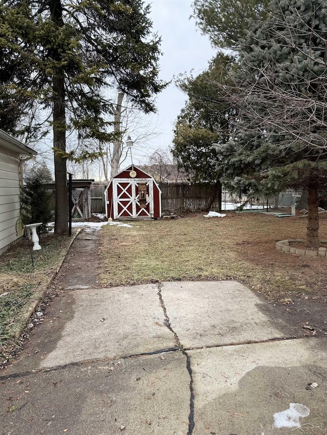 view of yard with an outbuilding, fence, and a storage unit