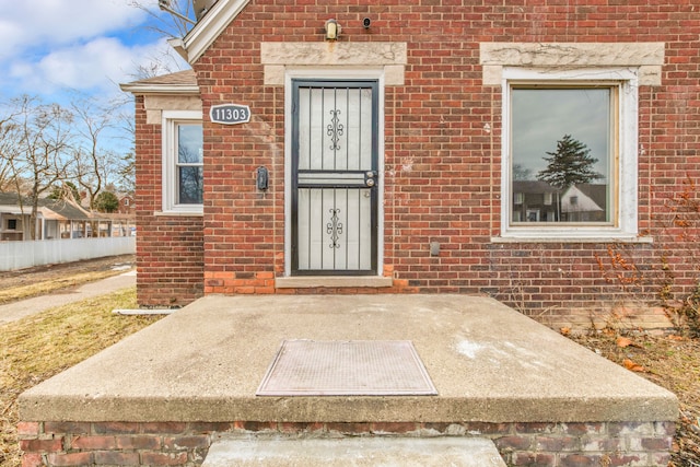 doorway to property featuring brick siding