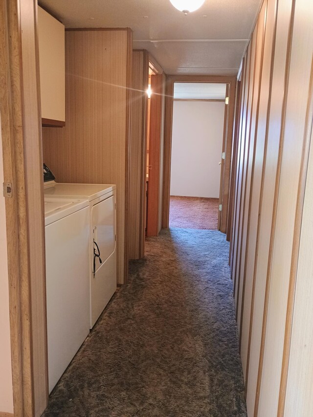 corridor with washing machine and clothes dryer, carpet flooring, and wooden walls