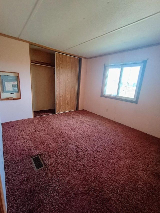 unfurnished bedroom with a closet, carpet, and visible vents