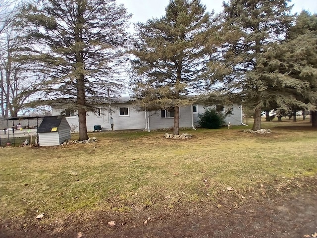 back of property with an outbuilding, a storage shed, and a lawn