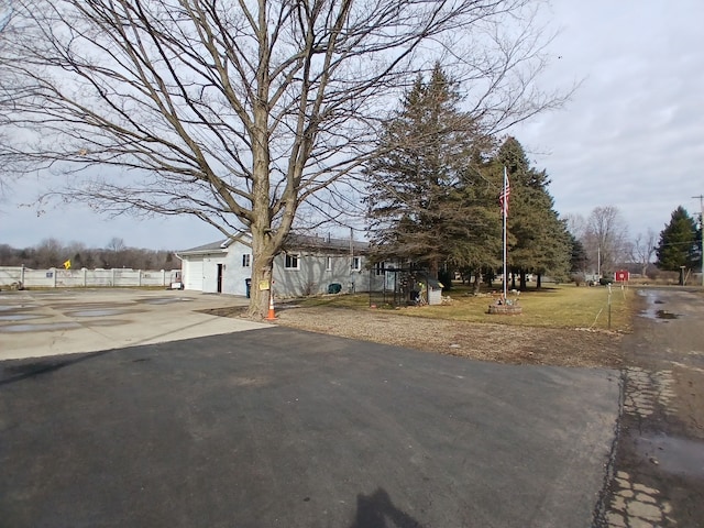 view of front of home with driveway and fence