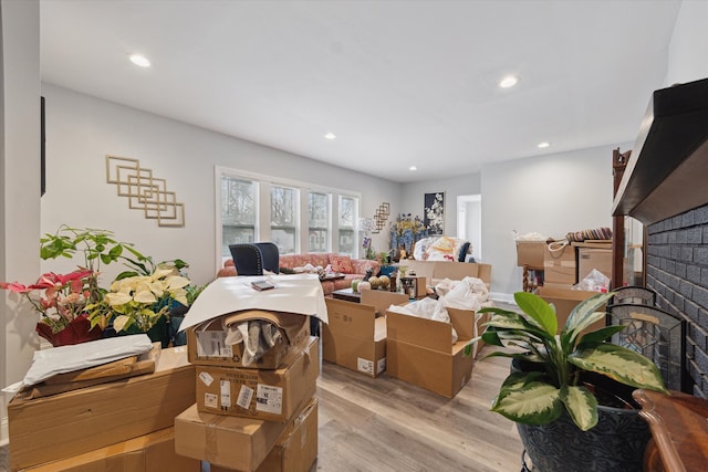 interior space featuring light wood-type flooring, a brick fireplace, and recessed lighting