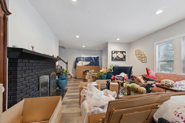 living area featuring light wood-type flooring, a fireplace, stairway, and recessed lighting