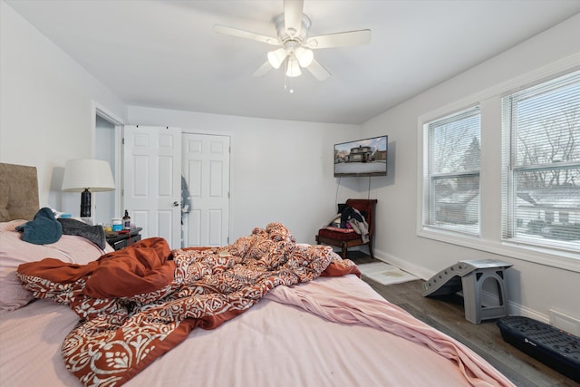 bedroom featuring ceiling fan, baseboards, and wood finished floors