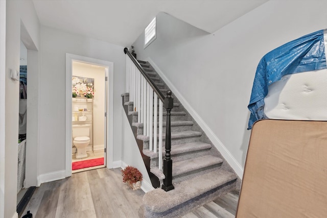 stairway with baseboards and wood finished floors