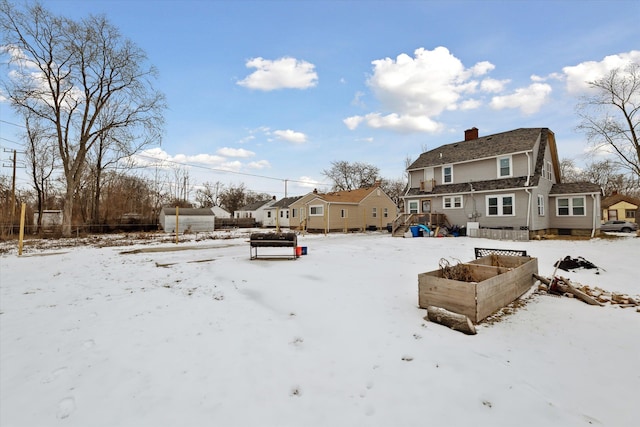 snowy yard featuring a vegetable garden