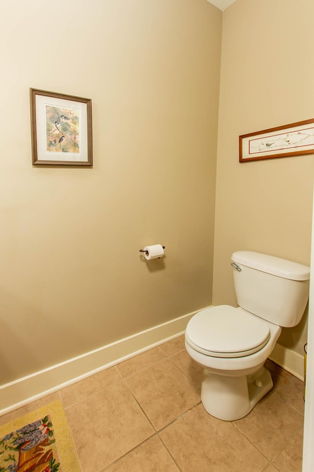 bathroom with baseboards, toilet, and tile patterned floors