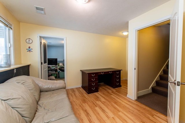 living area featuring stairs, light wood finished floors, visible vents, and baseboards