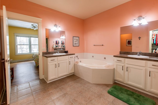 bathroom featuring tile patterned flooring, two vanities, a sink, and a bath