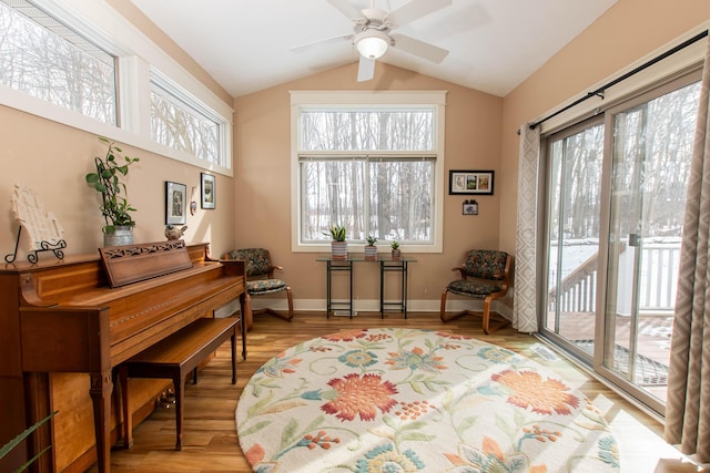 sitting room with a wealth of natural light, baseboards, vaulted ceiling, and light wood finished floors