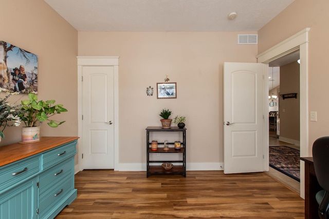 living area featuring visible vents, baseboards, and wood finished floors