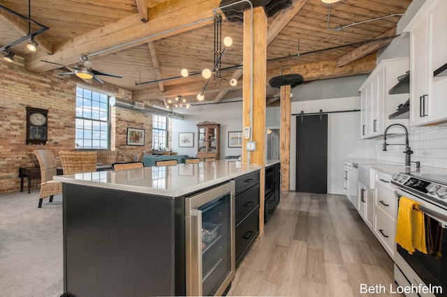 kitchen with a barn door, beverage cooler, wood ceiling, open floor plan, and stainless steel electric stove