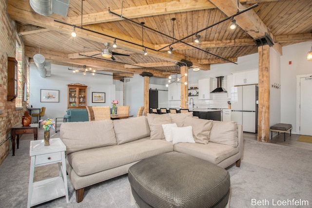 living room with rail lighting, wood ceiling, beamed ceiling, and light colored carpet