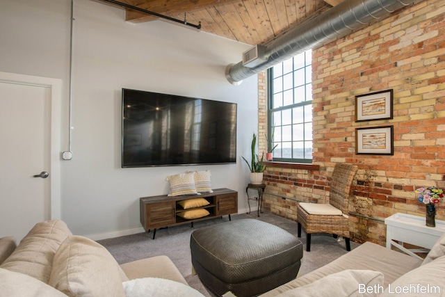 living area featuring carpet, baseboards, and brick wall