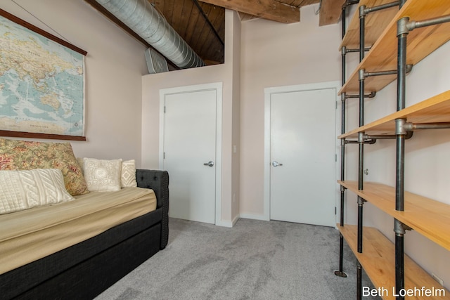 carpeted bedroom with beamed ceiling