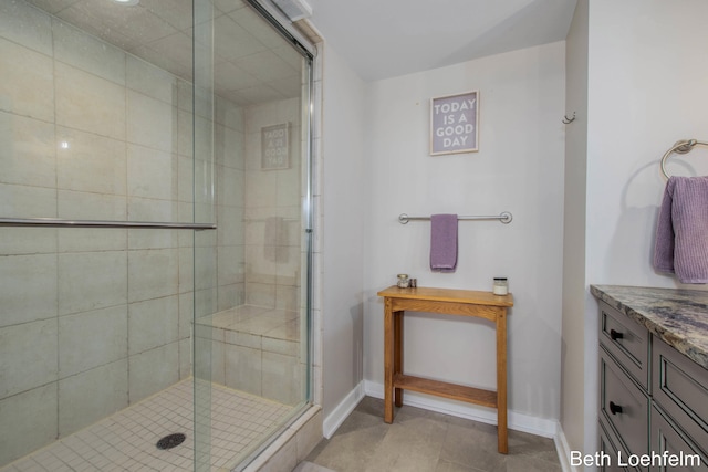 full bathroom featuring a stall shower, vanity, baseboards, and tile patterned floors