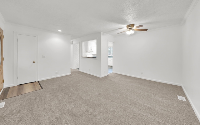 unfurnished living room with a textured ceiling, ceiling fan, carpet, and baseboards