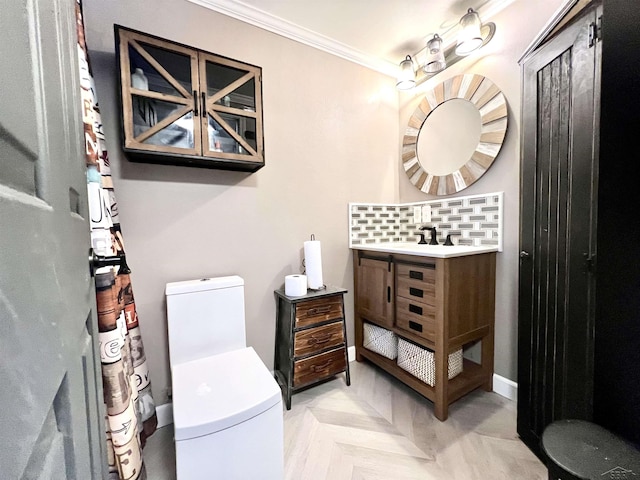 full bath featuring baseboards, crown molding, vanity, and toilet