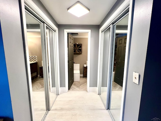 hallway featuring parquet floors and baseboards