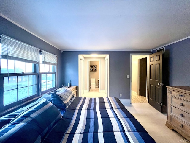 bedroom with baseboards, ensuite bath, and crown molding