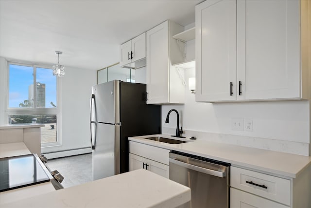 kitchen with white cabinets, stainless steel appliances, a sink, and light countertops