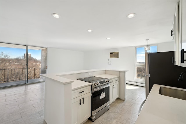 kitchen featuring a wall mounted AC, appliances with stainless steel finishes, a baseboard heating unit, white cabinets, and a sink