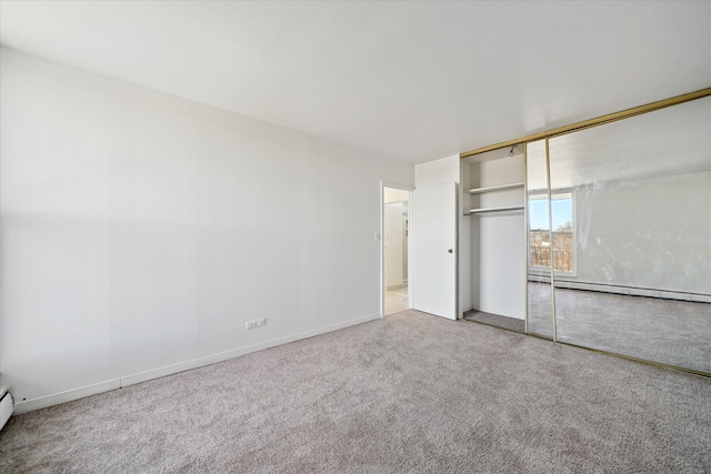 unfurnished bedroom with a baseboard radiator, baseboards, baseboard heating, a closet, and carpet