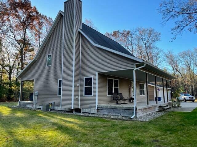 rear view of property with a patio area, a chimney, and a yard