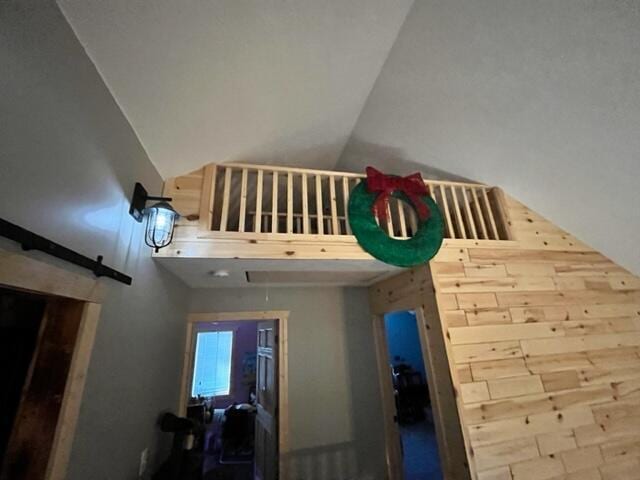 interior space featuring a barn door and high vaulted ceiling