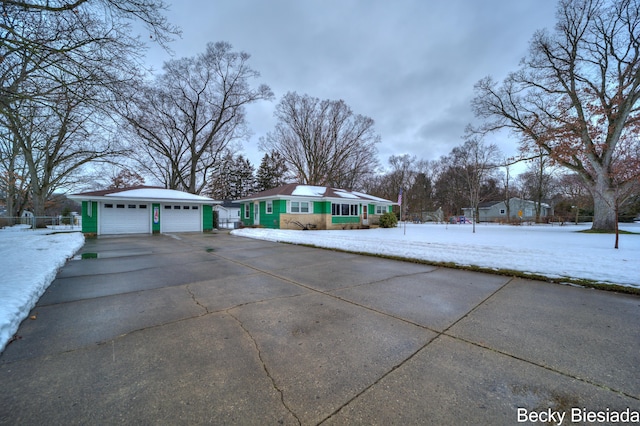 view of snow covered exterior with a garage, an outdoor structure, and fence