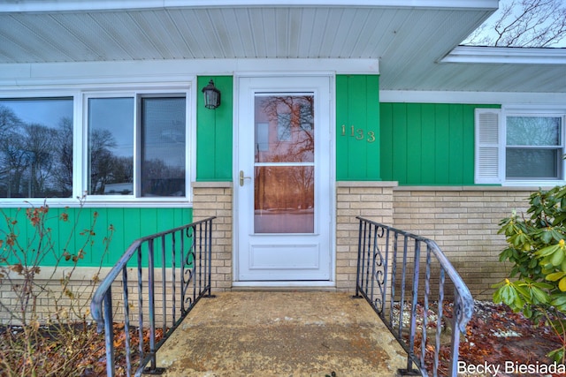 doorway to property featuring brick siding