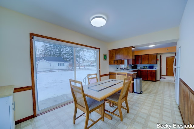 dining room featuring light floors and baseboards